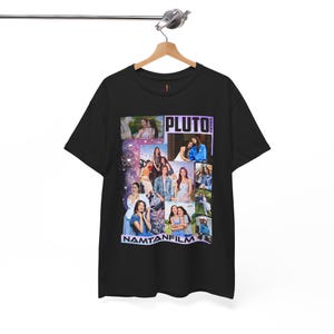 May include: Black t-shirt featuring a collage of images with the text "PLUTO" and "NAMTANFILM" in white and purple. The shirt is hanging on a wooden hanger against a white background.