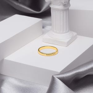 以下が含まれることがあります： 白い表面に「Rose & Jack」という刻印がされた金のバンドリングです。