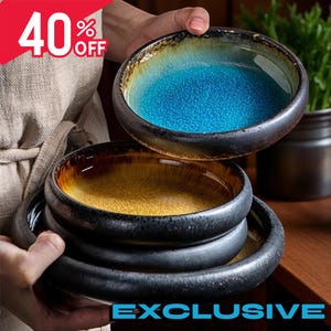 May include: A stack of ceramic bowls with a dark rim and a textured interior. The top bowl has a blue interior, while the lower bowls have a yellow interior. The image also includes the text "EXCLUSIVE".