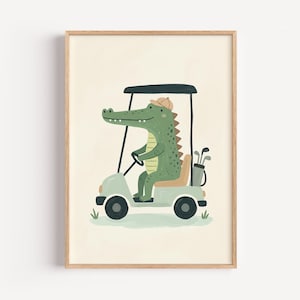 May include: A framed wall art print featuring a green alligator wearing a tan cap, driving a light green golf cart. The cart includes a tan seat, a black roof, and a golf bag with clubs in the back. The illustration is set against a cream background.