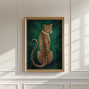 Può includere: Una stampa artistica incorniciata raffigurante un leopardo con un mantello maculato e un collare dorato, ambientata su uno sfondo verde scuro con fogliame tropicale. L'opera è racchiusa in una cornice dorata.