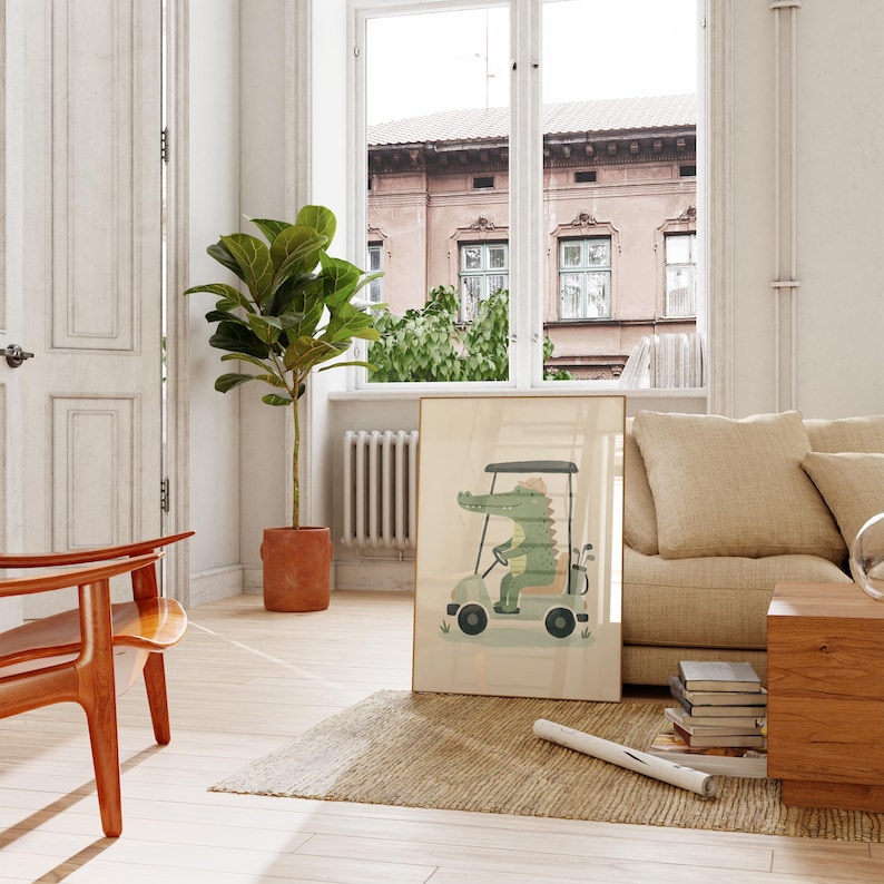 May include: A framed wall art print featuring a cartoon green crocodile driving a light-colored golf cart. The crocodile wears a hat and is positioned behind the steering wheel, with golf clubs visible in a bag attached to the back of the vehicle.