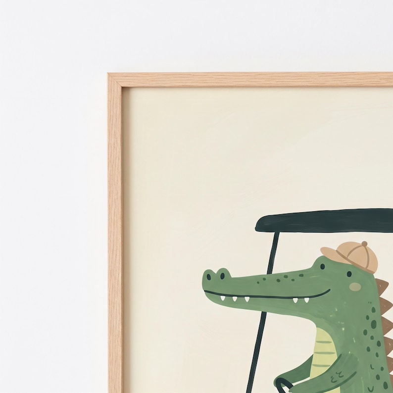 May include: A framed wall art print featuring a green crocodile wearing a tan cap while driving a dark green golf cart. The illustration is set against a solid cream-colored background and is enclosed in a light-toned wooden frame.