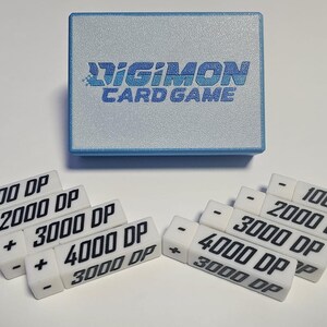 May include: A set of white plastic counters with black text for the Digimon Card Game. The counters are labeled with plus and minus signs and different point values: 1000, 2000, 3000, and 4000.