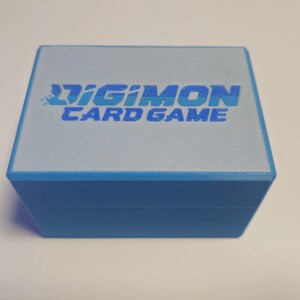 May include: A blue box with a white top and the text "Digimon Card Game" printed on it.