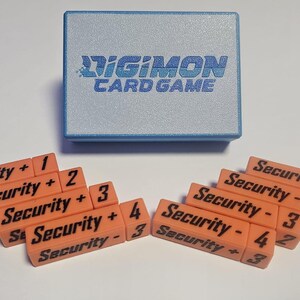 May include: A blue box with the text "DIGIMON CARD GAME" on the top.  There are ten orange blocks with black text that say "Security + 1", "Security + 2", "Security + 3", "Security + 4", "Security - 1", "Security - 2", "Security - 3", "Security - 4", "Security + 3", and "Security - 3".