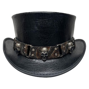 May include: Black top hat with a textured finish and a decorative band. The band features a snakeskin pattern, metal studs, and skull accents. The hat has a wide brim and a cylindrical crown.