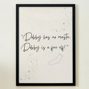 Könnte beinhalten: Ein schwarzer gerahmter Druck mit weißem Hintergrund und einem Zitat aus der Harry-Potter-Reihe: "Dobby hat keinen Meister. Dobby ist ein freier Elf!" Das Zitat ist in schwarzer Kursivschrift geschrieben. Kleine silberne Sterne sind um das Zitat verstreut und eine kleine Zeichnung einer Socke befindet sich in der rechten unteren Ecke.