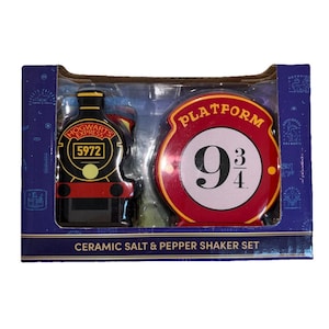 May include: A ceramic salt and pepper shaker set featuring a train and a Platform 9 3/4 design. The train is black with gold accents and the text "Hogwarts Express 5972". The Platform 9 3/4 is red with white text and a black number 9 3/4.