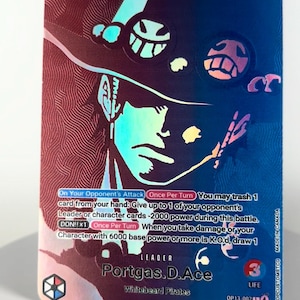 May include: A holographic trading card featuring the character Portgas D. Ace from the Whitebeard Pirates. The card has a blue and red color scheme with the number 6000 and the word "SPECIAL" visible. The card also includes game text.
