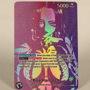 May include: A collectible trading card featuring Boa Hancock from the Seven Warlords of the Sea. The card has a holographic background with a portrait of Boa Hancock. The card includes text about gameplay and has a 5000 special rating.