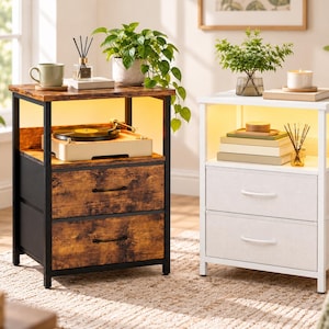 May include: Two bedside tables with integrated LED lighting, each featuring an open top shelf and two fabric drawers. One table has a dark wood grain finish with a black metal frame, while the other is white with a matching white metal frame.
