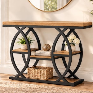 May include: A console table featuring a rectangular light brown wooden top and base with a black metal frame. The frame consists of two large intersecting circular supports. It includes two small side shelves, a central shelf, and a bottom shelf.