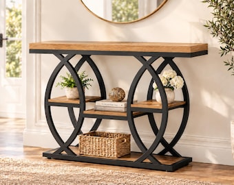 May include: A console table featuring a rectangular light brown wooden top and base with a black metal frame. The frame consists of two large intersecting circular supports. It includes two small side shelves, a central shelf, and a bottom shelf.