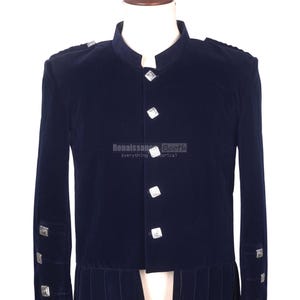 Puede incluir: Chaqueta de terciopelo azul marino con botones y detalles cuadrados plateados. La chaqueta tiene cuello mandarín y pliegues decorativos en la cintura. El logotipo de Renaissance Booth es visible.