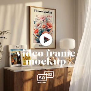 May include: A framed "Flower Market" poster with a floral design featuring pink and red flowers. The poster is displayed above a wooden cabinet with books and decorative items. The scene is illuminated by natural light.