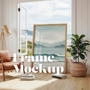 Puede incluir: Un gran cuadro enmarcado con una escena de paisaje costero, apoyado contra una pared cerca de una ventana abierta. El marco es de madera clara y la obra presenta tonos azules y verdes. El texto "Frame Mockup" está superpuesto.