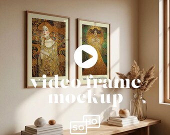 May include: Two framed art prints with gold and brown tones hang on a beige wall. The prints feature detailed illustrations of women in ornate gowns. A wooden bench below holds books, a vase, and decorative objects. The text "video frame mockup" is overlaid.