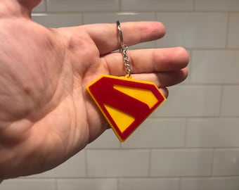 Llavero con logotipo impreso en 3D inspirado en superhéroe