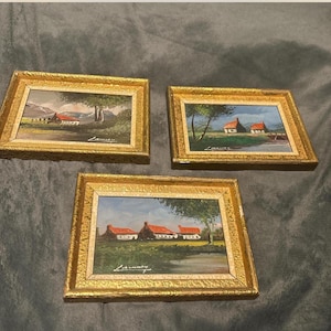 Set of 3 vintage oil paintings on canvas board in gold frames, featuring landscapes and a cottage art. Signed by artist