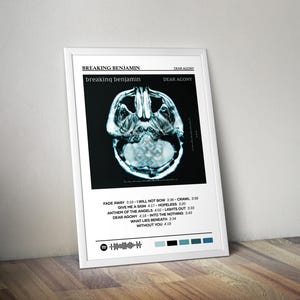 May include: White framed poster featuring the band Breaking Benjamin's album "Dear Agony." The poster includes the album title, song titles, and a stylized image of a human skull. The color palette is primarily black, white, and shades of blue.