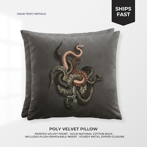 May include: Two gray velvet pillows with a detailed illustration of intertwined snakes in shades of brown, green, and pink. The pillows have the text "YOUR TEXT/INITIALS" and "SHIPS FAST". The pillows are labeled "POLY VELVET PILLOW".