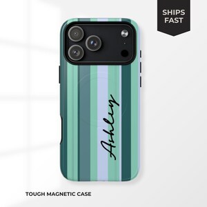 May include: A tough magnetic phone case with a vertical striped pattern in shades of green and blue. The name "Ashley" is written in a cursive font. The case has a black camera module.