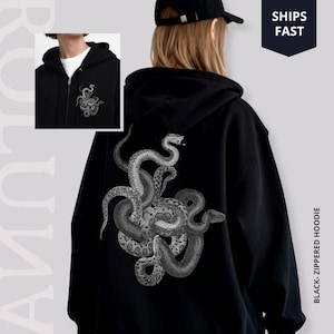 Könnte beinhalten: Schwarzer Kapuzenpullover mit Reißverschluss und einer detaillierten Graustufen-Illustration von verschlungenen Schlangen auf dem Rücken. Auf der linken Brust befindet sich ein kleineres, passendes Schlangendesign. Der Hoodie hat eine Kapuze und einen Reißverschluss.
