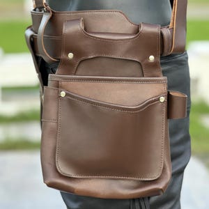 Close-up of full-grain brown leather texture with precision stitching, highlighting handmade craftsmanship.