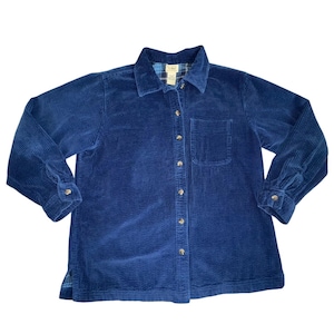 May include: A navy blue corduroy shirt with a button-down front, a chest pocket, and long sleeves. The collar features a plaid lining. The shirt has gold-colored buttons and buttoned cuffs. The fabric has a ribbed texture.