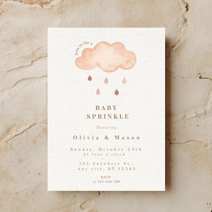 May include: A baby sprinkle invitation with a watercolor design. The invitation features a peach-colored cloud with raindrops, the text "BABY SPRINKLE", and details for Olivia & Mason's event. The invitation is on a textured, off-white background.