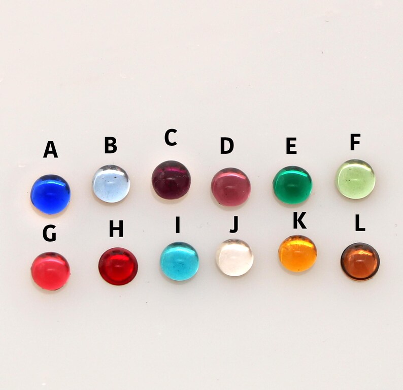 Pu&ograve; includere: Dodici perline di vetro rotonde in vari colori, tra cui blu, rosso, verde e trasparente. Le perline sono disposte in due file di sei, etichettate con le lettere da A a L.