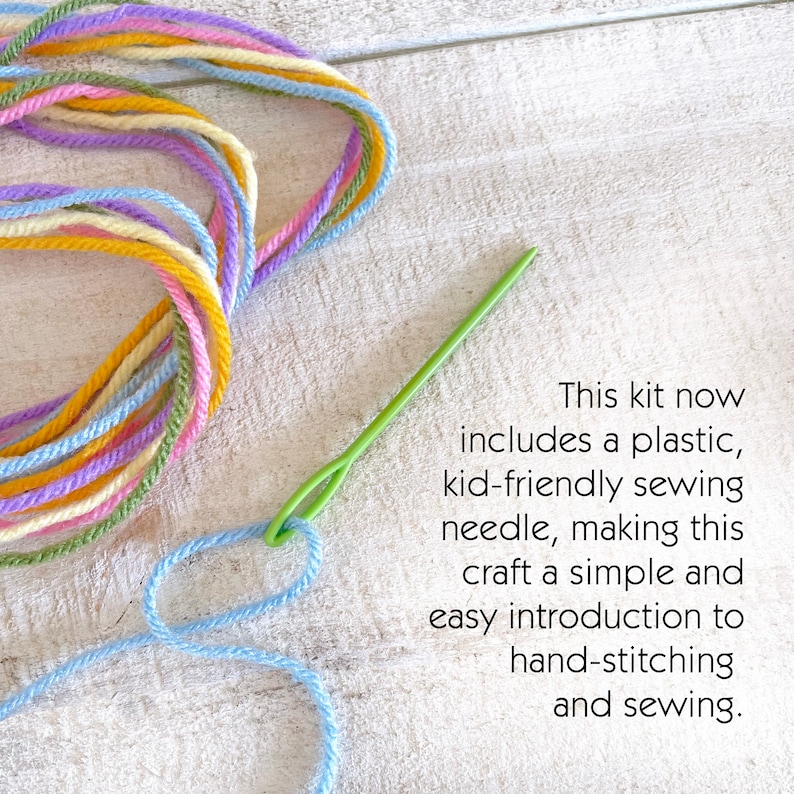 Pu&ograve; includere: Un kit artigianale con fili colorati nei toni del giallo, blu, viola e verde. Un ago da cucito in plastica verde &egrave; infilato con filo blu. Il testo sull'immagine recita: "Questo kit ora include un ago da cucito in plastica adatto ai bambini."