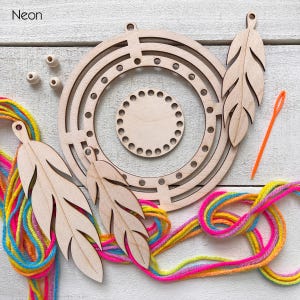 May include: A wooden dream catcher kit with a circular frame, feather cutouts, wooden beads, and colorful yarn. An orange needle is also included. The word "Neon" is in the upper left corner.
