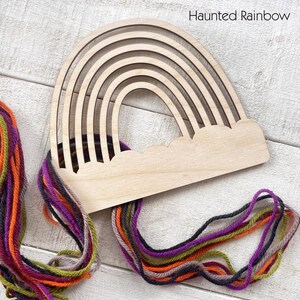 Pu&ograve; includere: Un telaio per tessitura a forma di arcobaleno in legno con base a nuvola. Il telaio &egrave; realizzato in legno chiaro e presenta pi&ugrave; fessure arcuate. Filato colorato nelle tonalit&agrave; dell'arancione, viola, verde e grigio &egrave; attaccato al telaio. Il testo "Haunted Rainbow" &egrave; visibile.