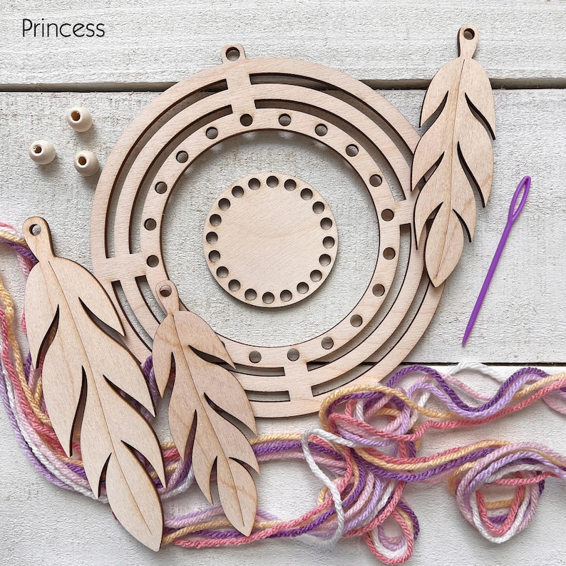 May include: A wooden dream catcher kit with a circular frame, feather-shaped cutouts, and a small circular base. The kit includes wooden beads, a purple needle, and colorful yarn in shades of pink, purple, and yellow. The word "Princess" is in the top left corner.