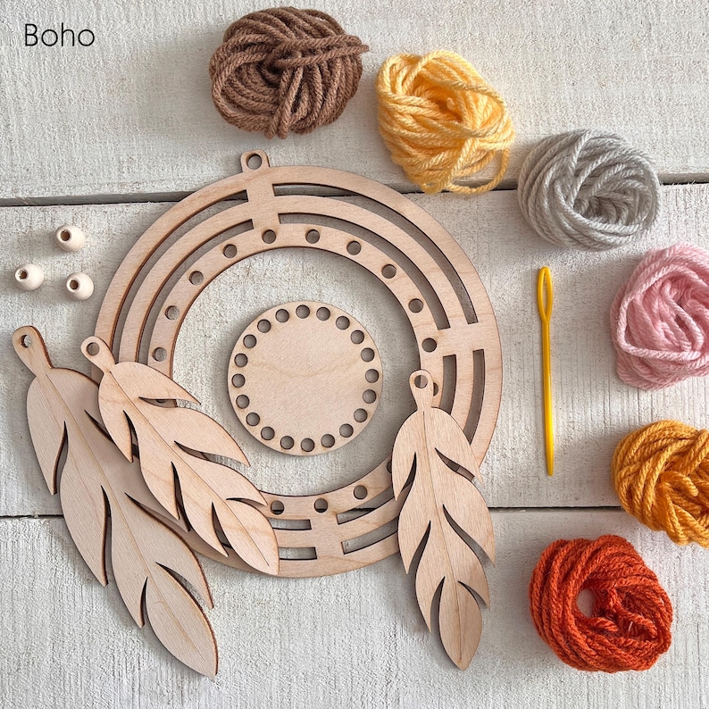 May include: A craft kit with a wooden dream catcher frame, feathers, and a small circular base. Various colors of yarn, a yellow needle, and wooden beads are also included. The word "Boho" is in the top left corner.