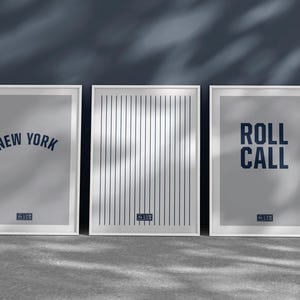 Puede incluir: Tres impresiones enmarcadas con marcos blancos y fondos grises. La impresión de la izquierda dice "NEW YORK" en texto azul. La impresión del medio tiene un patrón de rayas verticales. La impresión de la derecha dice "ROLL CALL" en texto azul.