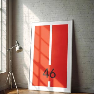 Puede incluir: Una impresión enmarcada con un fondo rojo y una línea vertical blanca en el centro. El número 46 está impreso en negro sobre el fondo rojo.