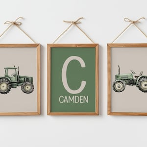 May include: Three framed prints with a farm theme. Two prints feature green tractors on a beige background. The centre print has a green background with the letter "C" and the name "CAMDEN" in white. The frames are wood.