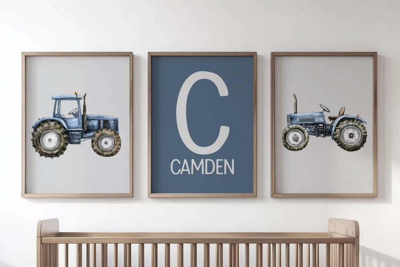 May include: Three framed prints featuring a blue tractor illustration and a blue print with the name "Camden". The tractor art has a watercolor style with a light blue color scheme. The frames are a light brown color.