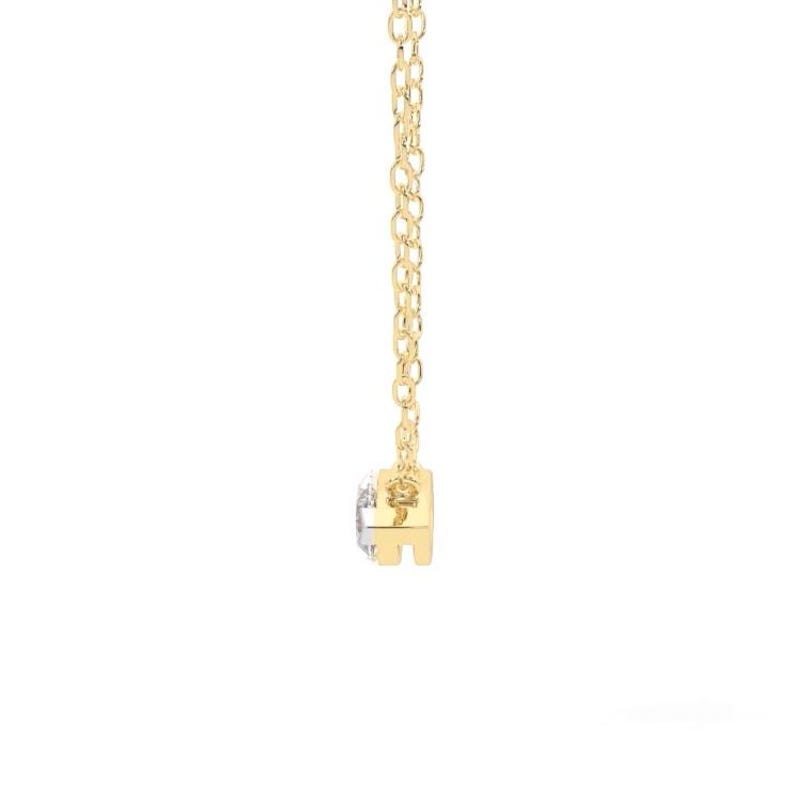 May include: A delicate gold necklace featuring a small, round, clear gemstone pendant. The pendant is set in a gold bezel and hangs from a fine gold chain. The necklace is displayed against a white background.