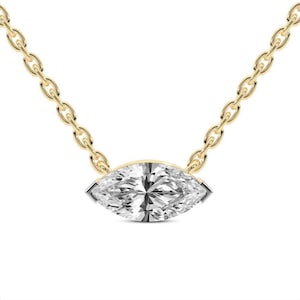 May include: A gold chain necklace featuring a marquise-cut diamond pendant. The diamond is set in a gold bezel and sparkles with many facets. The chain is delicate and has a classic link design.