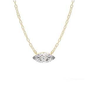May include: A gold chain necklace featuring a marquise-cut diamond pendant. The diamond is set in a bezel setting and sparkles with many facets. The chain is delicate and has a classic link design.