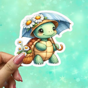 May include: A whimsical sticker featuring a cartoon turtle with a straw hat adorned with daisies, holding a blue umbrella and a basket of flowers. The turtle has a light green body and a tan shell. The sticker is held by a hand.