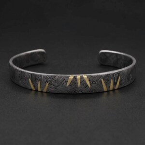 Bracciale rigido in acciaio di Damasco forgiato a mano con inserto in ottone.