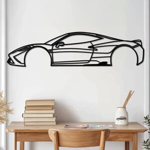 May include: Black metal wall art depicting a side profile of a sports car. The car is outlined in a simple, minimalist style.