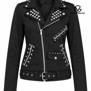 May include: A black jacket featuring silver-toned pyramid studs on the lapels, shoulders, and pockets. The garment includes a diagonal front zipper, multiple zippered pockets, a small flap pocket, and a buckled belt at the waist. Gothic Vibes NYC logo.