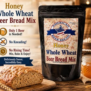 May include: A black pouch of Honey Whole Wheat Beer Bread Mix with a label featuring a star-spangled logo and Wisconsin Made text. The packaging lists instructions: Only 1 Beer is Needed, No Kneading, and No Rising Time. A loaf of bread sits nearby.