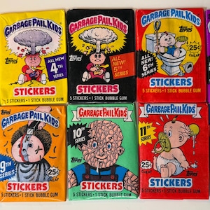 May include: A collection of ten vintage Garbage Pail Kids sticker packs from Topps, featuring various colorful illustrations of characters, including series numbers 3rd through 14th, each labeled with the text Stickers, 5 stickers, and 1 stick bubble gum.
